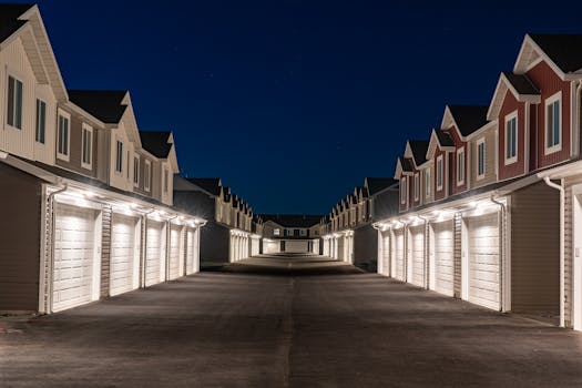 A well-lit residential area featuring rows of modern townhouses at night in Hyrum, Utah.