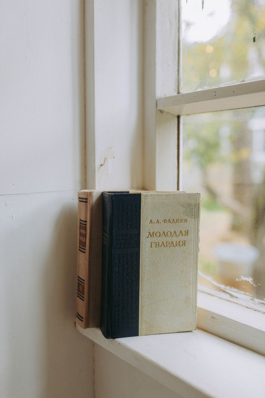Two vintage books resting on a window sill in natural light, evoking nostalgia.