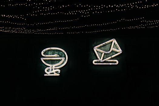 一张以鸡尾酒杯和霓虹灯信封标志为背景的图像，充满活力