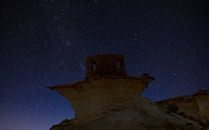 Breathtaking view of the starry night sky above Zekreet's unique rock formation.