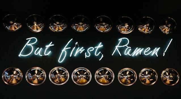 Bright neon sign with reflection, highlighting ramen with metallic hubcaps.