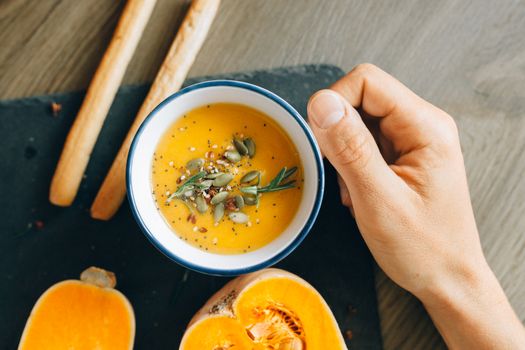 A delicious bowl of homemade pumpkin soup garnished with seeds and spices.