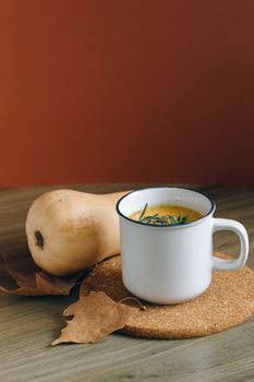 Warm and comforting butternut squash soup served in a mug, perfect for fall.