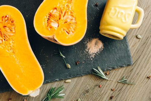 Free A close-up shot of halved butternut squash with rosemary sprigs and salt on slate. Stock Photo
