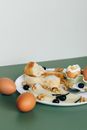 早餐布置得很时尚，盘中有煮鸡蛋、奶酪片、橄榄和新鲜面包