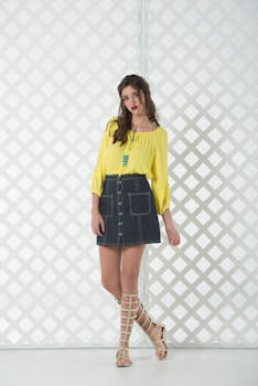 Stylish portrait of a woman in a yellow top and denim skirt, perfect for summer fashion.