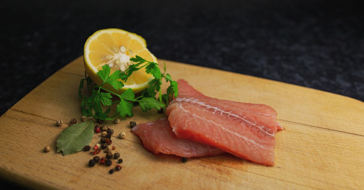 fresh salmon fillet with lemon and olive oil on a rustic kitchen counter