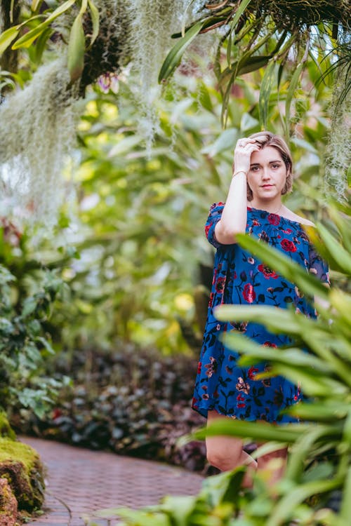 Attractive woman touching hair gently in tropical garden