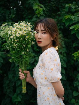 年轻女性侧身拿着花束，手背在身后看向镜头