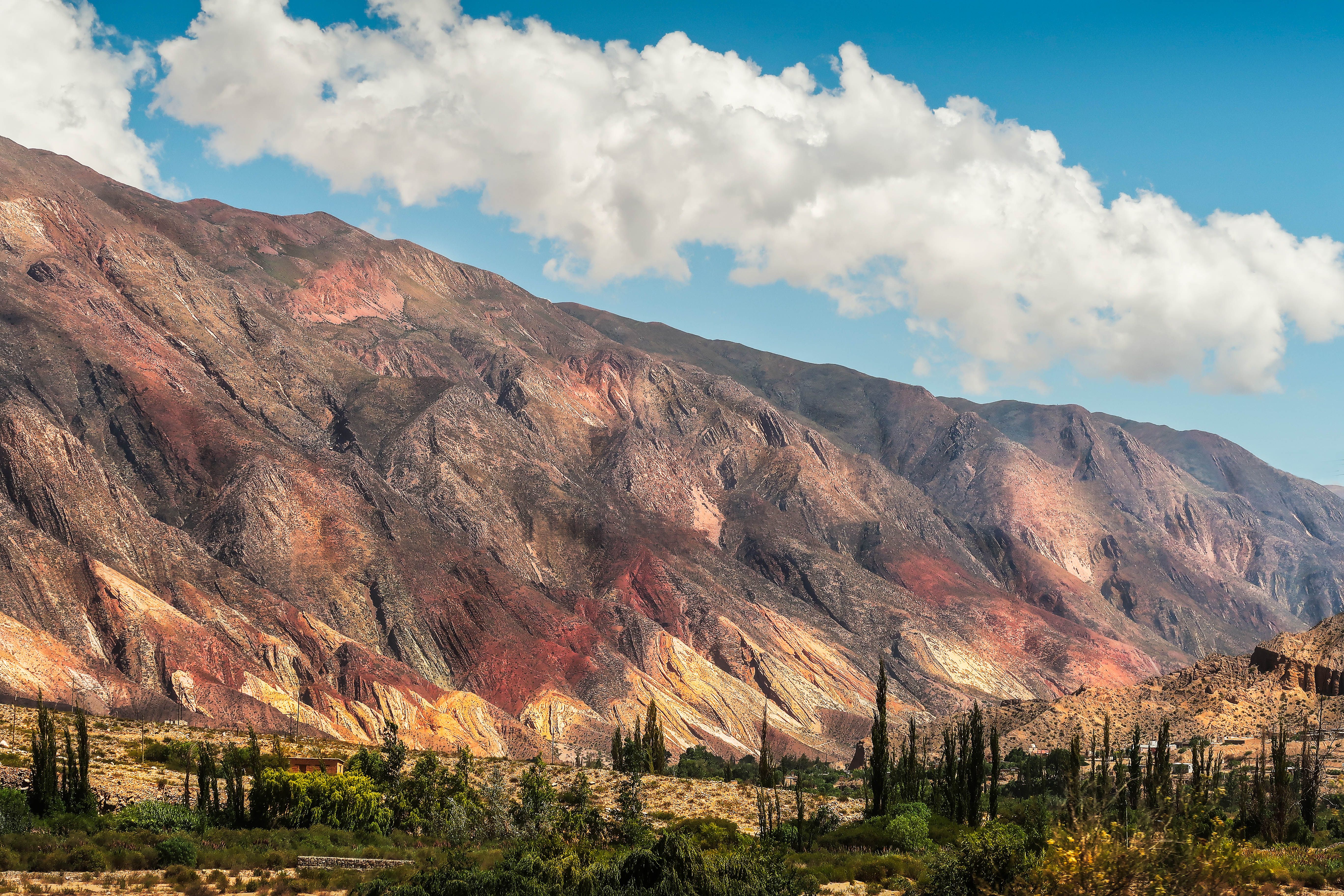 Vibrant rock formations in the Quebrada de Humahuaca Valley under a bright blue sky. - Quebrada de Humahuaca