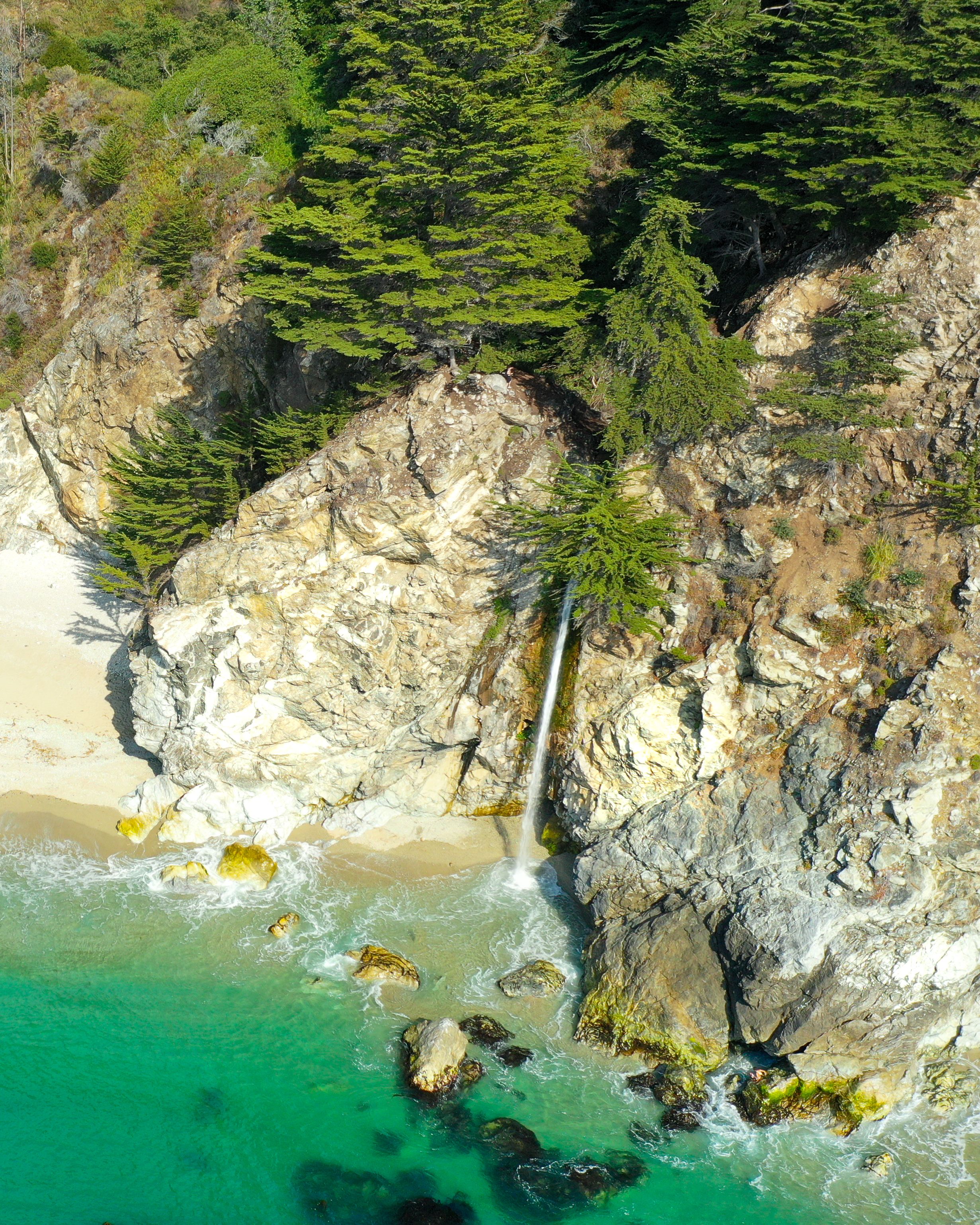 从空中俯瞰，粗糙的岩石海岸、碧绿的海水和绿色的热带植物尽收眼底