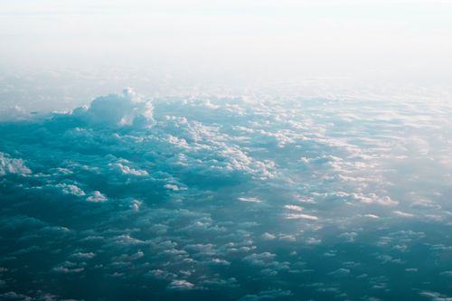 Free Stunning aerial view of a cloudscape beneath a bright blue sky, creating a serene atmosphere. Stock Photo