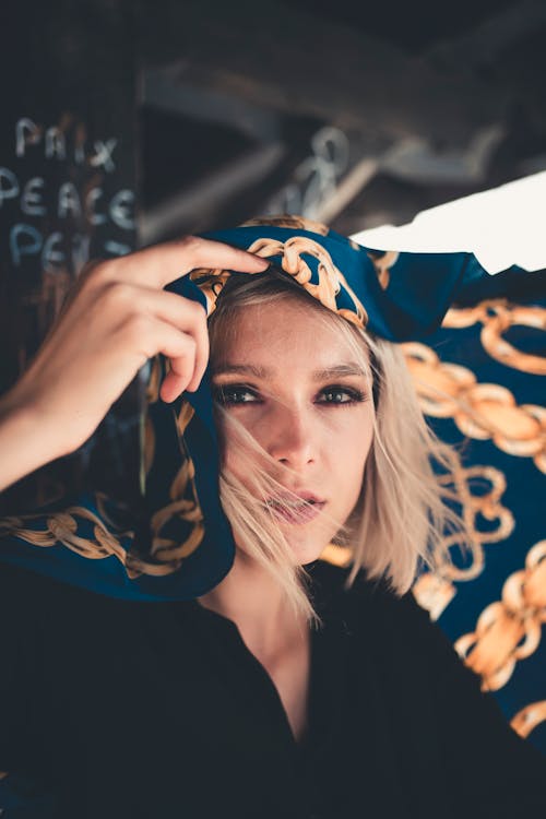 Free Woman in Black Shirt Covering Her Face With Blue and White Textile Stock Photo