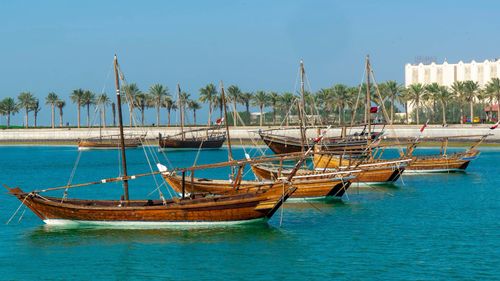 Free Wooden boats floating in blue water of sea and moored in harbor under cloudless blue sky in sunny day Stock Photo