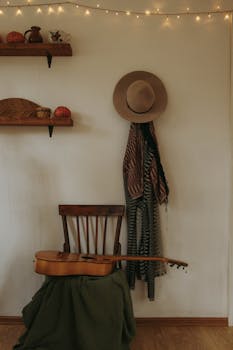Warm indoor scene featuring a guitar, hat, and wooden chair with a cozy vibe.