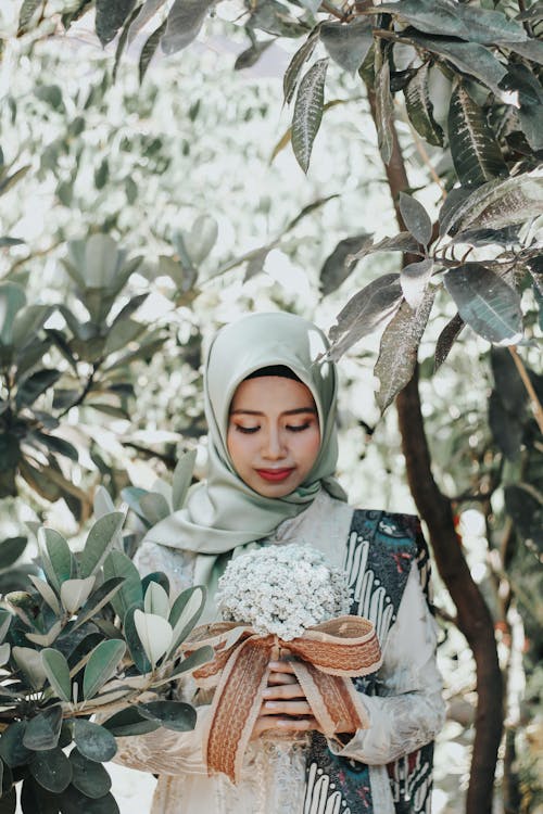 Woman Wearing Hijab Holding Bouquet of Flowers