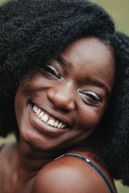 Happy adult African American female with perfect skin smiling while looking at camera