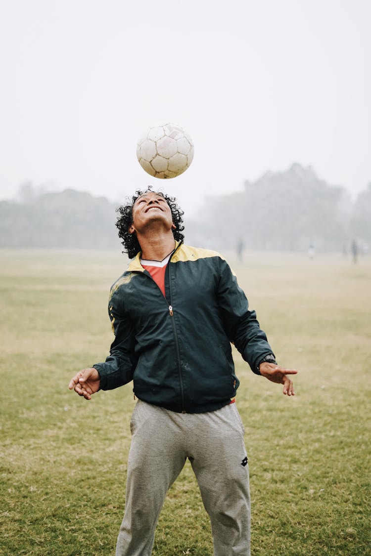 Adult Happy Sportsman Hitting Ball With Head