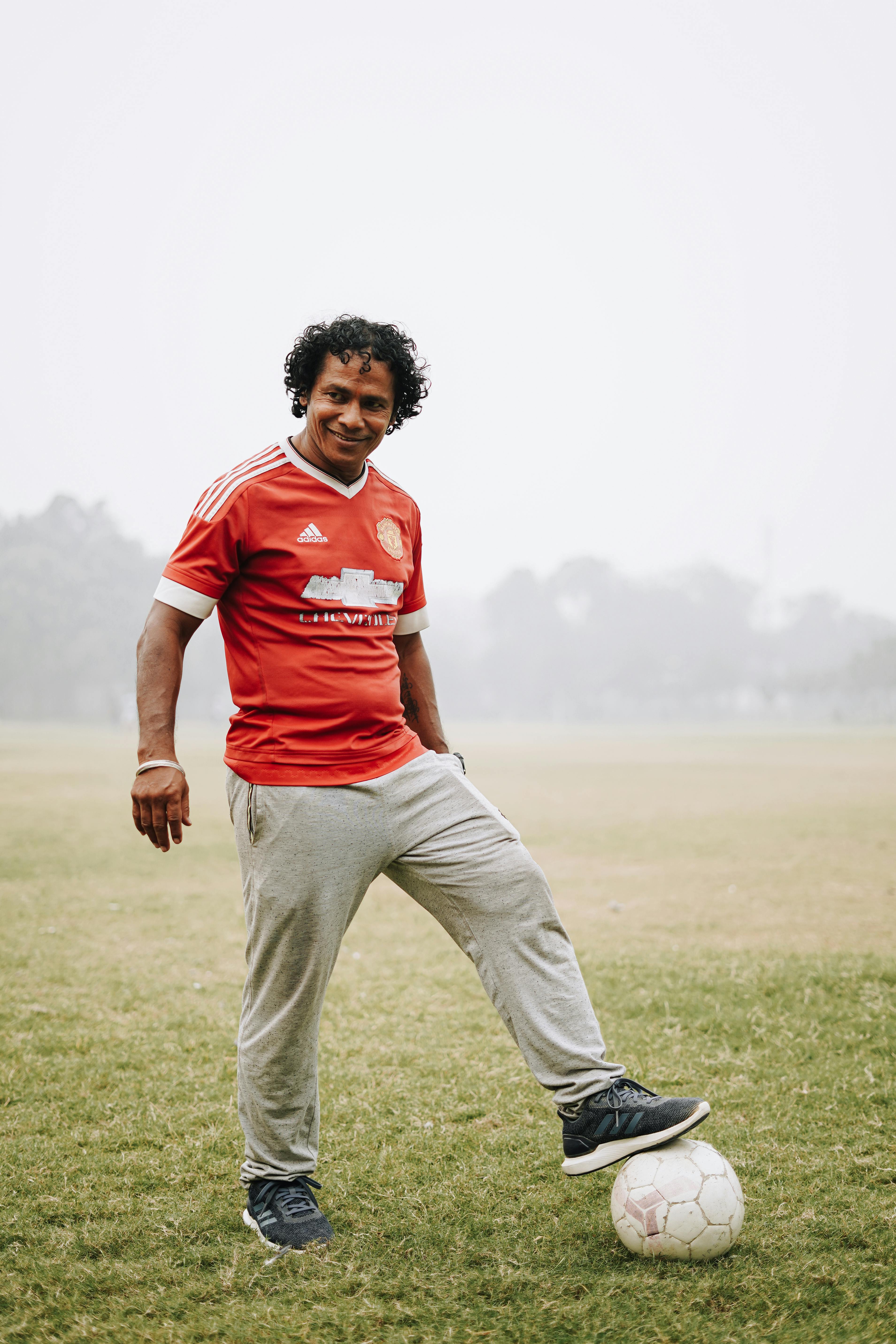 smiling ethnic sportsman with soccer ball