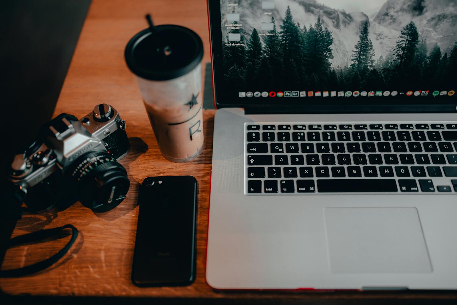 Iced coffee beside a laptop on a wooden table