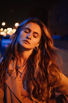 这是一幅描绘闭眼女子的艺术肖像，她长发飘逸，戴着圆环耳环，背景是夜晚