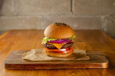 Stacked burger on a wooden board, photo by Italo Melo on Pexels