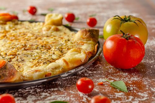 Free Delicious cheese pizza with fresh tomatoes, seasoned to perfection. Stock Photo