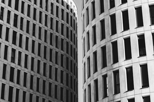 Black and white of simple majestic gray multi storey construction with long narrow same windows in daytime
