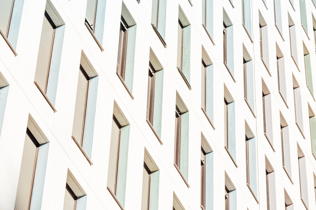 From below of lots of long narrow identical windows of contemporary construction in sunlight