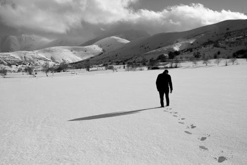 A Man Walking on the Snow Field