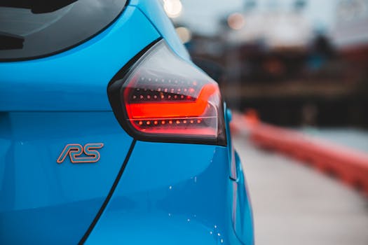 Modern sport automobile with glowing red taillight and reflection on polished body