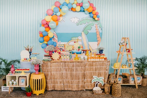 Birthday area with colorful balloons over decorated table with festive cake and presents