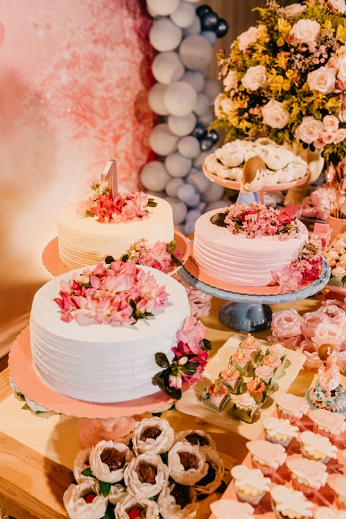 High angle of delicious sweet cakes decorated with flowers near appetizing desserts on wedding party