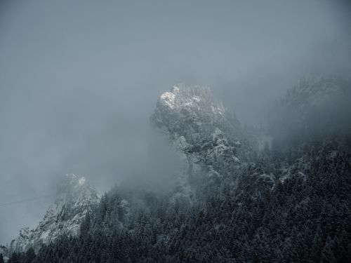 Free A serene view of snow-covered mountains enveloped in fog, showcasing the beauty of nature in winter. Stock Photo