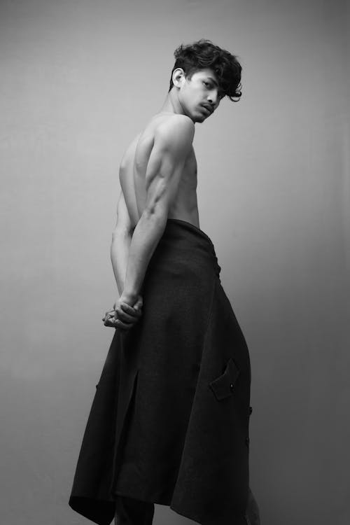 Shirtless ethnic male model with hands behind back in studio