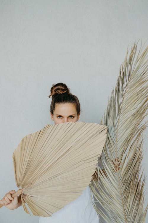 Woman Covering Her Body With Dried Palm Leaves