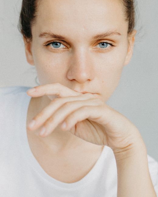 Close-up portrait of a woman with blue eyes, looking thoughtful and serene.
