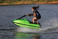 Woman in Black and Blue Wetsuit Riding Green and White Surfboard