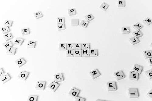 Free White Scrabble tiles displaying 'STAY HOME' on a pristine white background, emphasizing home isolation. Stock Photo