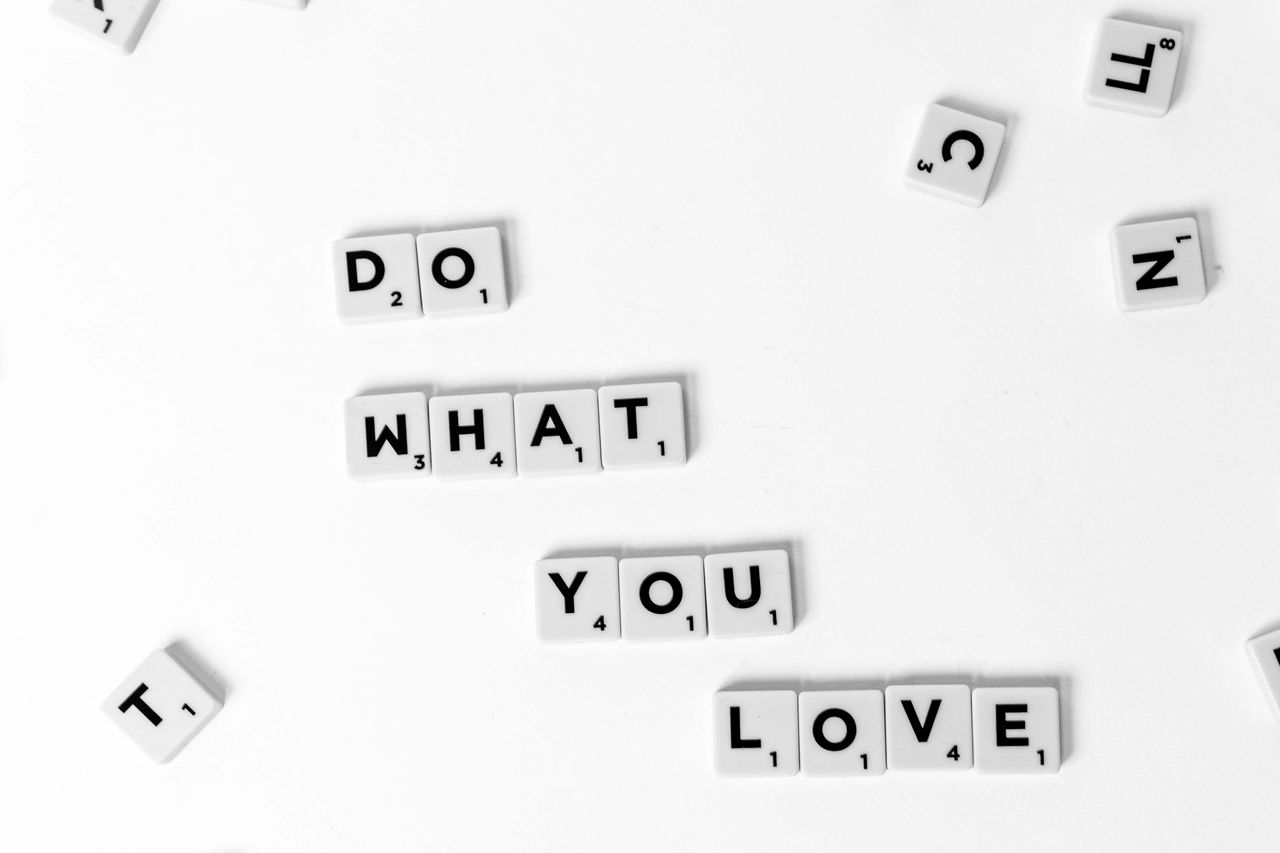 scrabble tiles spelling do what you love on a white background encoura