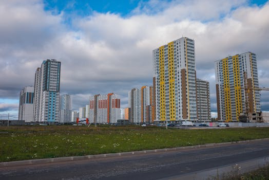 High-rise residential buildings under cloudy skies in an urban setting with ample green space.