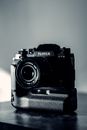 Digital photo camera on table in bright room