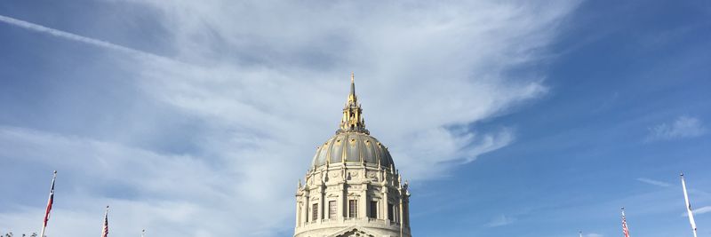 Majestic view of San Francisco City Hall with clear blue sky and classic architecture.