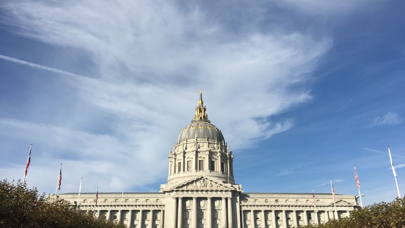 Majestic view of San Francisco City Hall with clear blue sky and classic architecture.