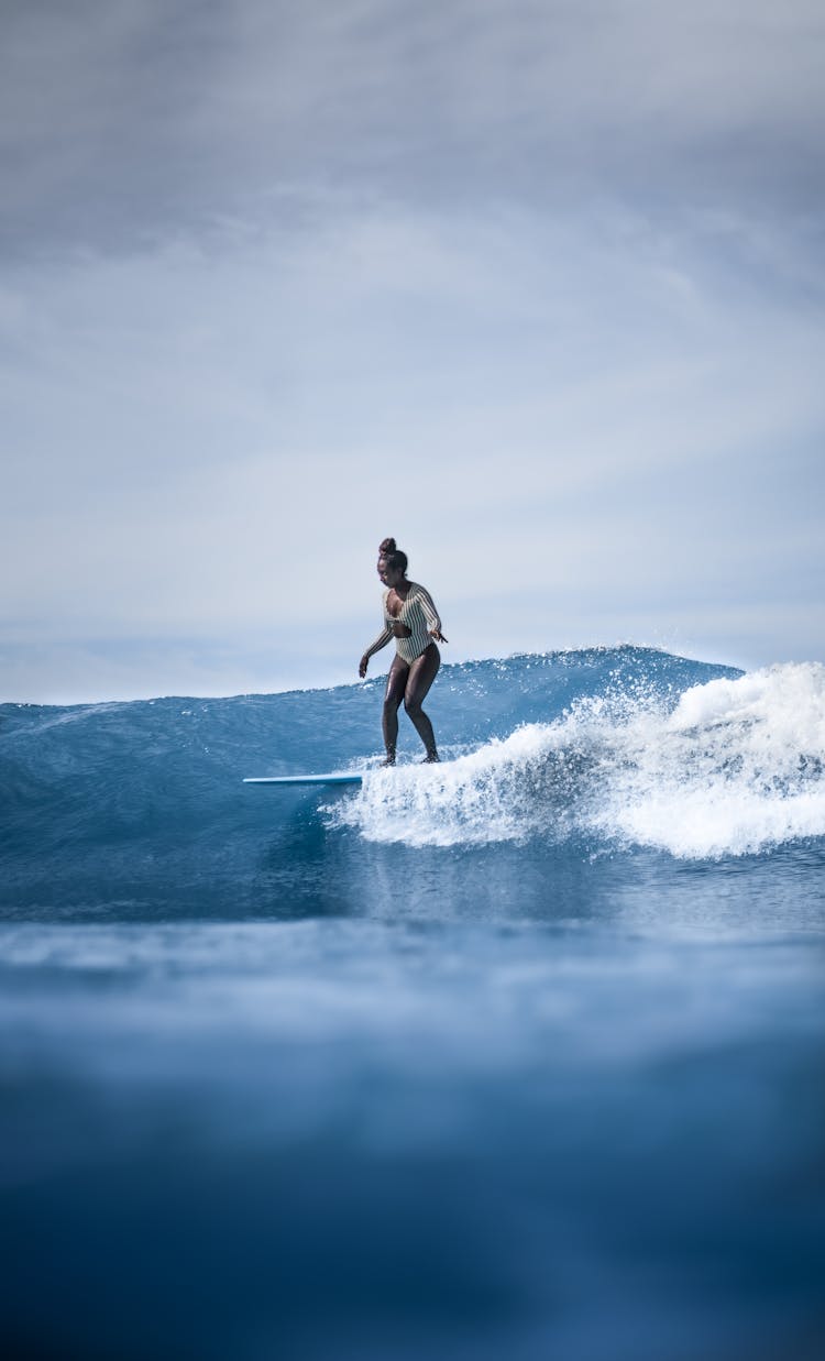 Amateur Black Female Surfer Riding Surfboard On Seawater