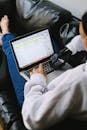Person in White Long Sleeve Shirt Using Macbook Pro