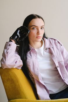 一位自信的女人穿着粉色夹克，戴着假肢坐在室内