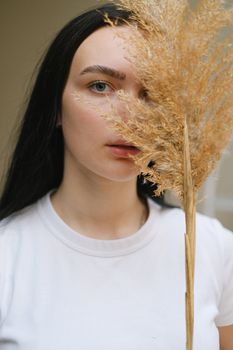 一位年轻女子的肖像平静地隐藏在干燥的潘帕斯草中