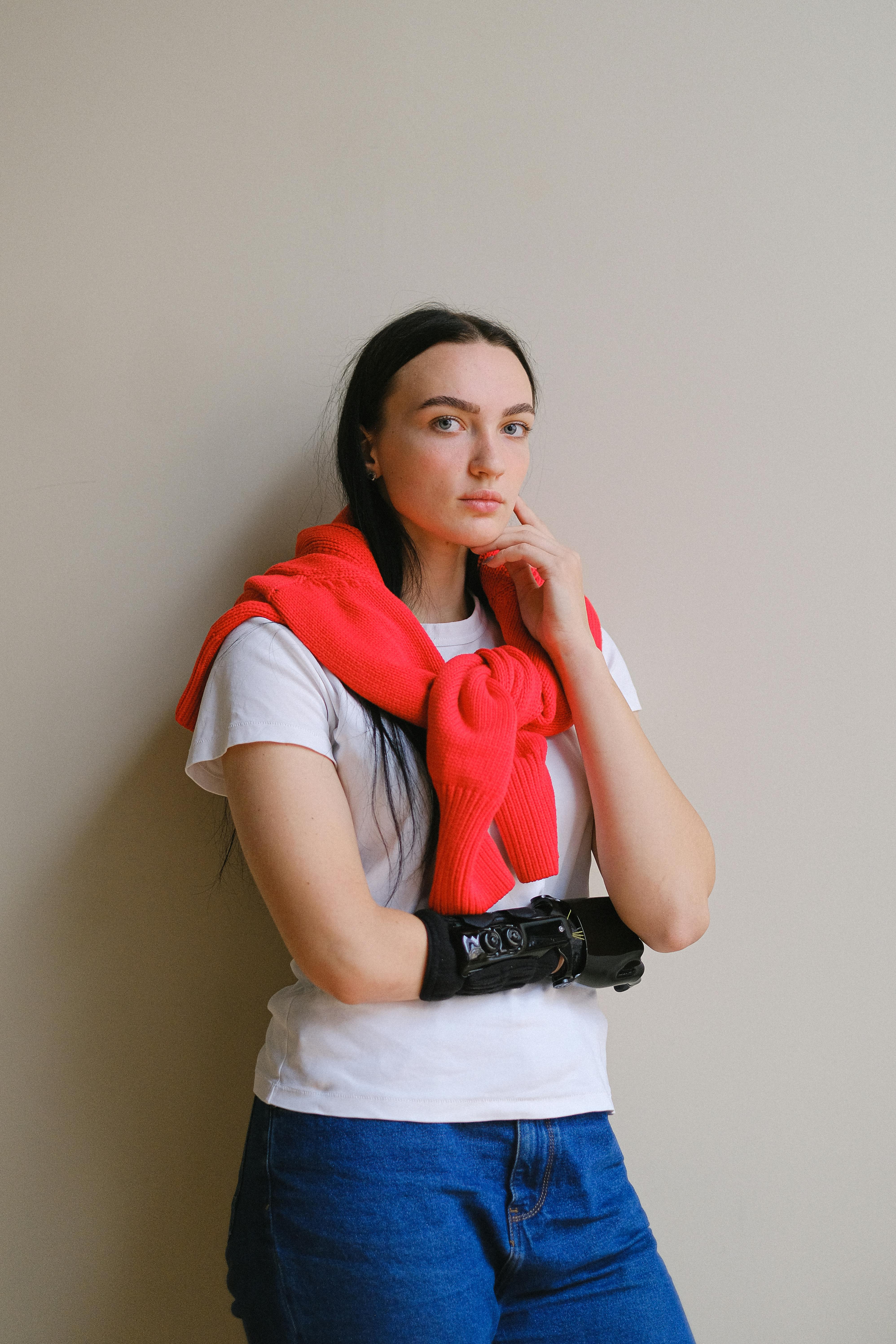 一位穿着休闲装、戴着假臂的时尚女性在室内摆出自信的姿势，突显了现代科技感