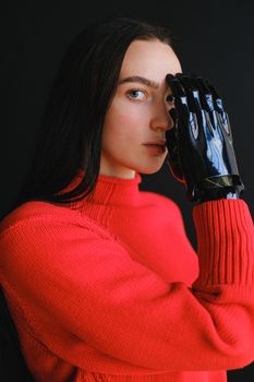 这张优雅的工作室肖像描绘了一位身穿红色毛衣、佩戴假肢的女性，展现了现代技术与风格的融合